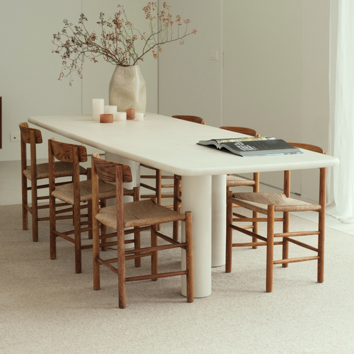Beige soumak tapijt gecombineerd met meubels in een eetkamer.ALT
