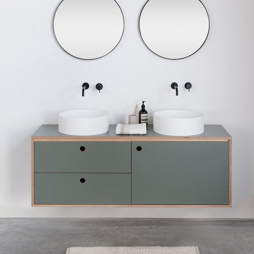 Ronde waskommen op groene badkamermeubel met zwarte moderne kranen en spiegels