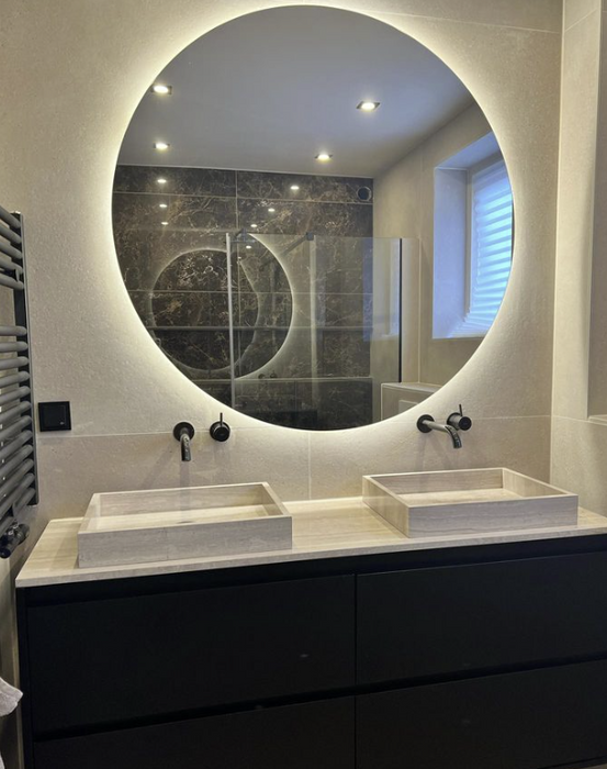 Zwarte badkamerkast met grote LED spiegel, marmeren lavabo en meubelblad en zwarte inbouwkranen