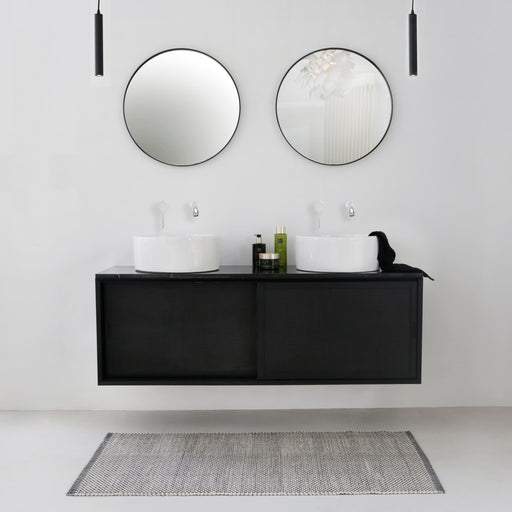 zwart rotan zwevende badkamerkast met ronde lavabo's en moderne kranen
